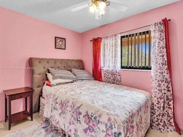 tiled bedroom featuring a textured ceiling and ceiling fan