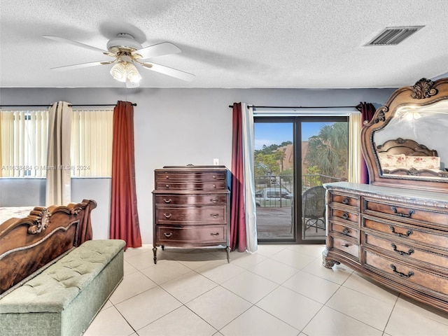 tiled bedroom with access to outside, ceiling fan, and a textured ceiling