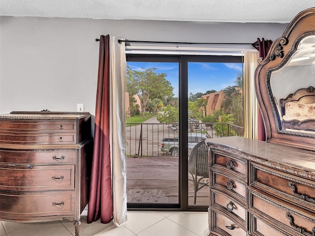 doorway featuring light tile patterned floors and a textured ceiling