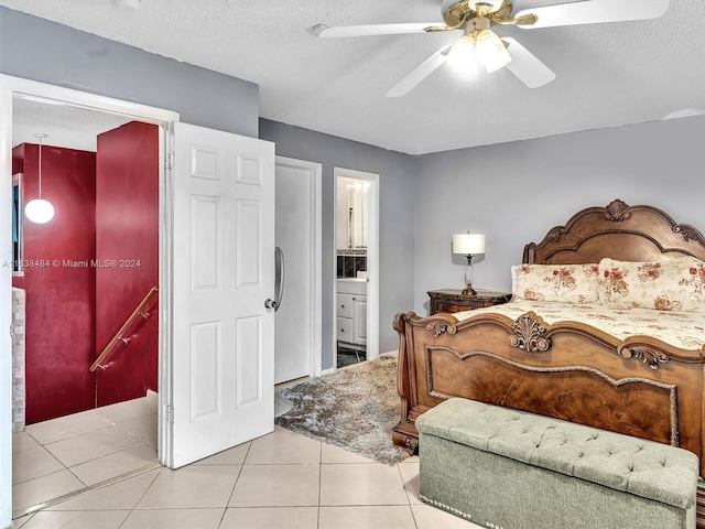 bedroom featuring light tile patterned floors, a textured ceiling, ensuite bath, and ceiling fan