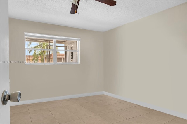 tiled empty room with a textured ceiling and ceiling fan