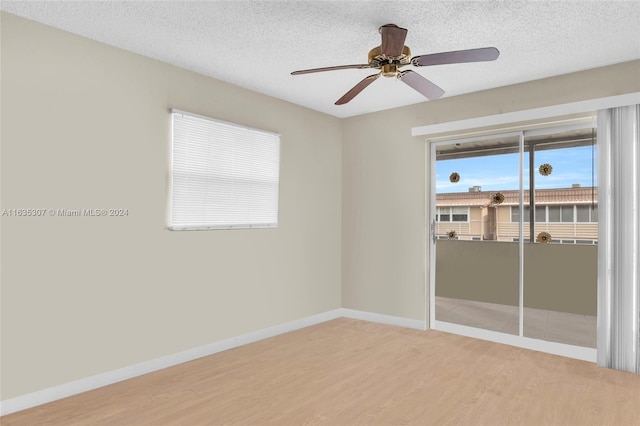 empty room featuring plenty of natural light, a textured ceiling, hardwood / wood-style floors, and ceiling fan