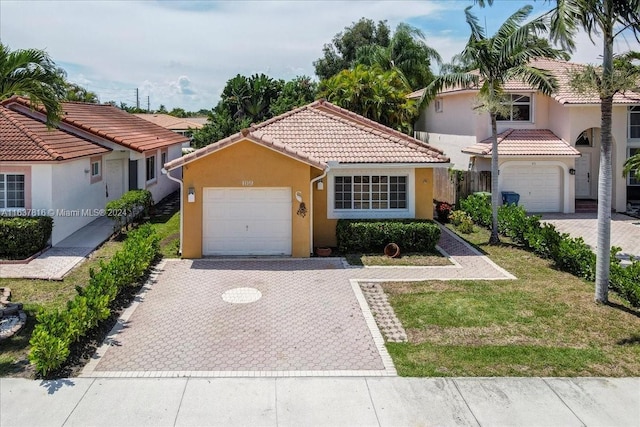 mediterranean / spanish home featuring a garage and a front lawn