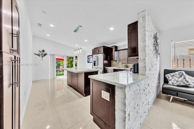 kitchen with high quality fridge, tasteful backsplash, pendant lighting, and light tile patterned floors