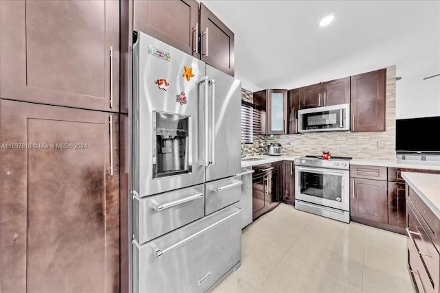 kitchen with appliances with stainless steel finishes, dark brown cabinets, tasteful backsplash, and light tile patterned floors