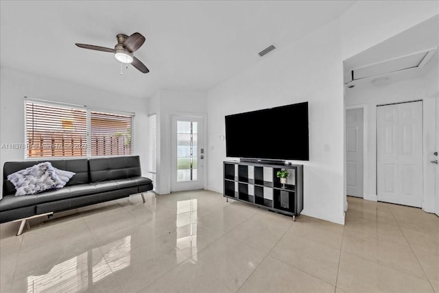 tiled living room featuring ceiling fan and vaulted ceiling