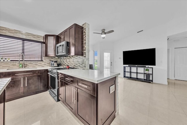 kitchen featuring tasteful backsplash, light tile patterned flooring, appliances with stainless steel finishes, and sink