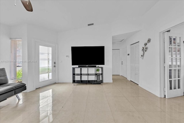 unfurnished living room featuring ceiling fan and light tile patterned flooring