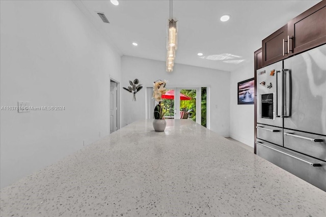 kitchen featuring light stone countertops, hanging light fixtures, and high end refrigerator