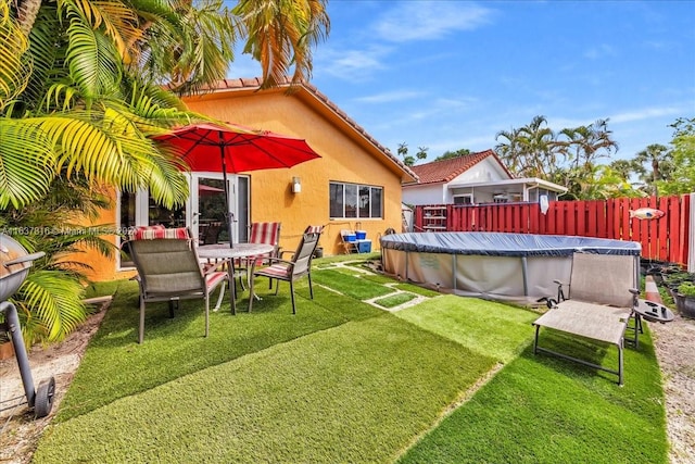 back of house featuring a covered pool and a yard