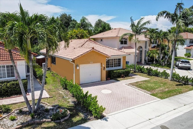 mediterranean / spanish house featuring a front lawn and a garage