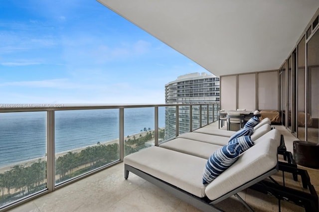 balcony with a water view and a view of the beach