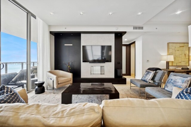 living room with a fireplace and expansive windows