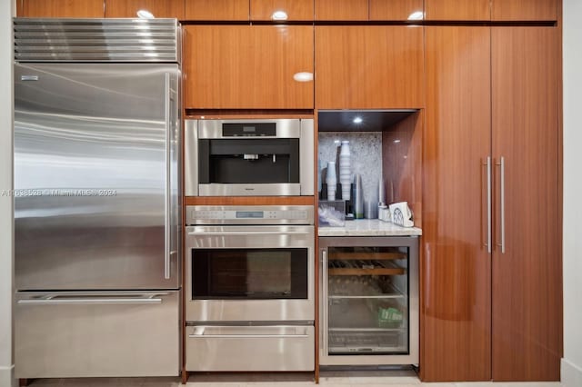 kitchen with light stone counters, wine cooler, and stainless steel appliances