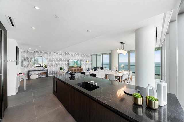 2000 S Ocean Dr Unit 31B, Hallandale Beach, FL 33009 - kitchen featuring a sink, dark brown cabinetry, dark stone counters, open floor plan, and pendant lighting