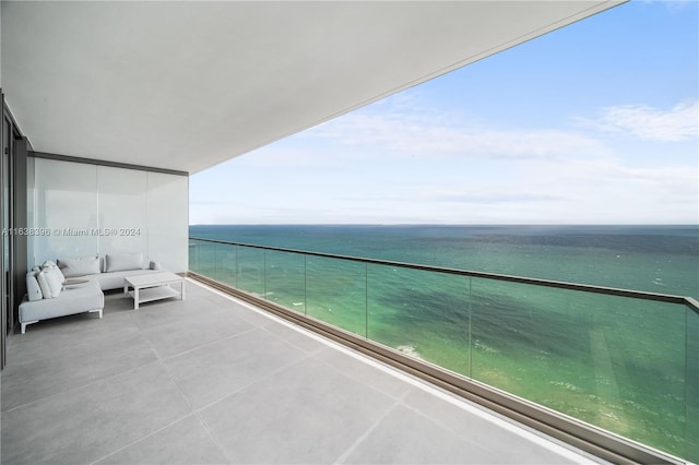 balcony featuring a water view and an outdoor living space