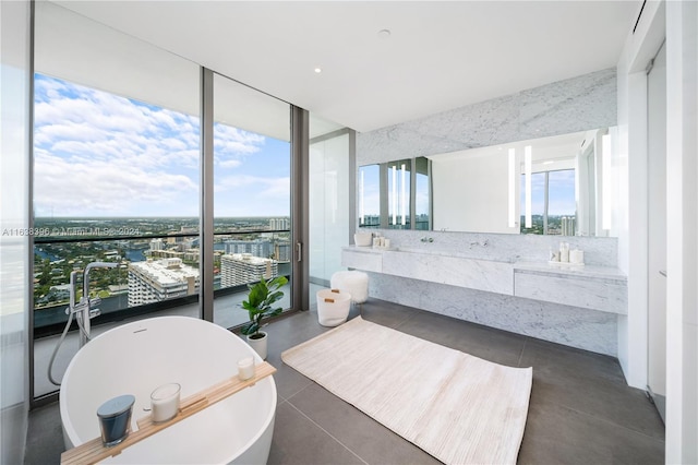 2000 S Ocean Dr Unit 31B, Hallandale Beach, FL 33009 - bathroom featuring a wall of windows, a freestanding bath, vanity, and a view of city