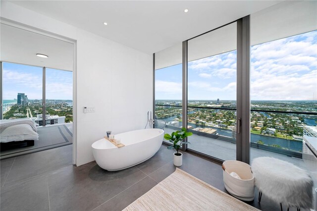 2000 S Ocean Dr Unit 31B, Hallandale Beach, FL 33009 - full bathroom featuring a wall of windows, healthy amount of natural light, a view of city, a freestanding bath, and a water view