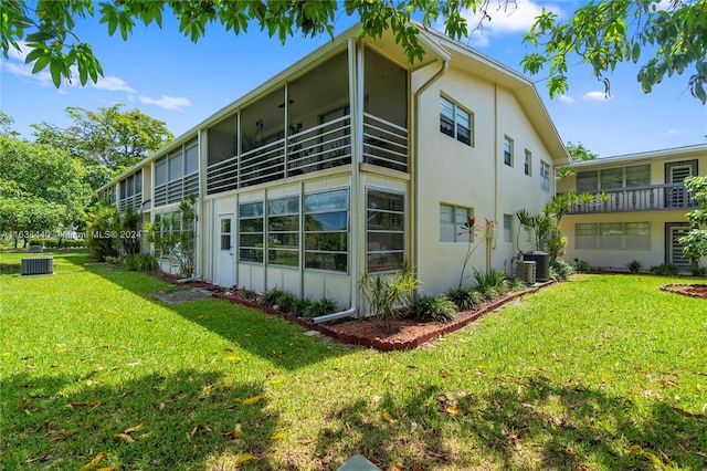 view of property exterior with central AC unit and a yard