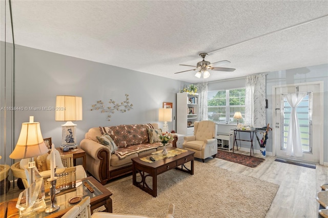 living room featuring ceiling fan, a textured ceiling, and hardwood / wood-style flooring