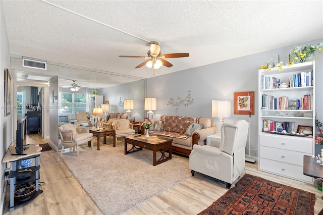 living room featuring a textured ceiling, light hardwood / wood-style floors, and ceiling fan