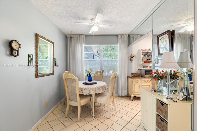 dining space featuring a textured ceiling, ceiling fan, and light tile patterned flooring