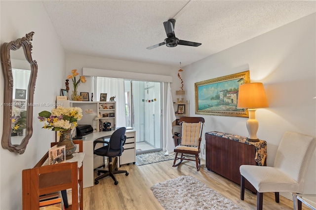 office featuring ceiling fan, a textured ceiling, and light wood-type flooring