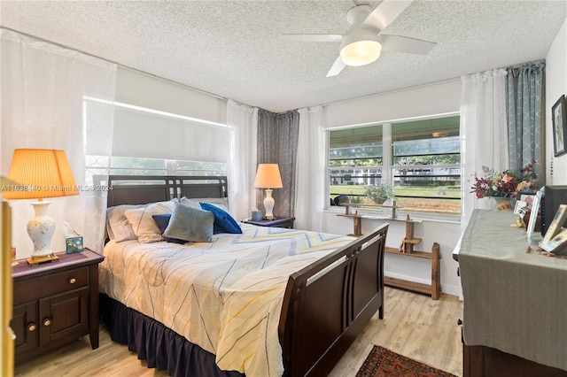 bedroom featuring ceiling fan, a textured ceiling, and light wood-type flooring