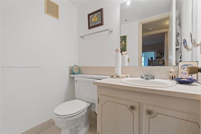 bathroom with tile patterned flooring, vanity, and toilet