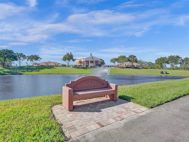 view of community with a water view and a lawn