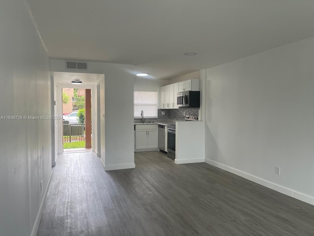 kitchen featuring sink, dark wood-type flooring, stainless steel appliances, and white cabinetry