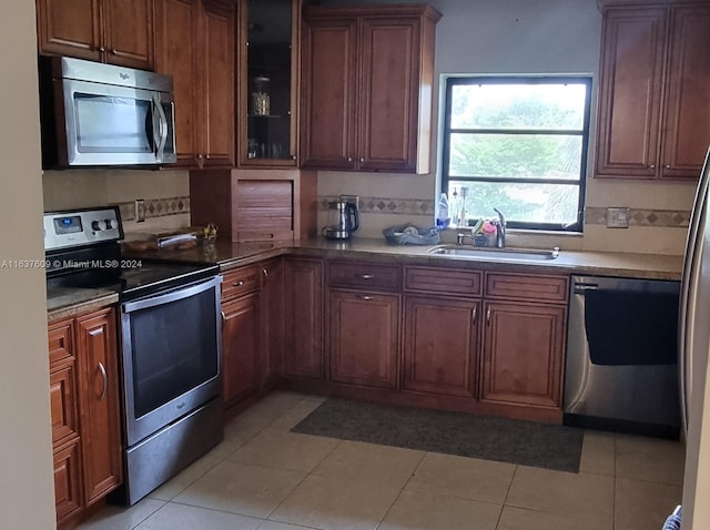 kitchen with sink, light tile patterned floors, and stainless steel appliances