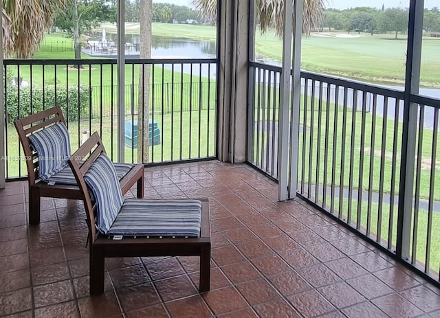 sunroom featuring a water view