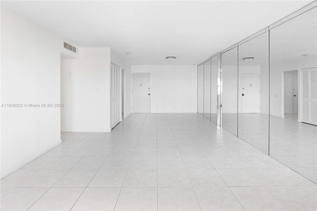 tiled spare room with a textured ceiling