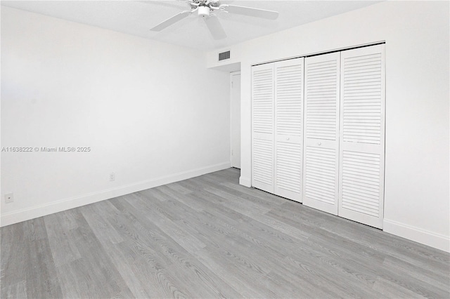 unfurnished bedroom with ceiling fan, light hardwood / wood-style floors, and a closet