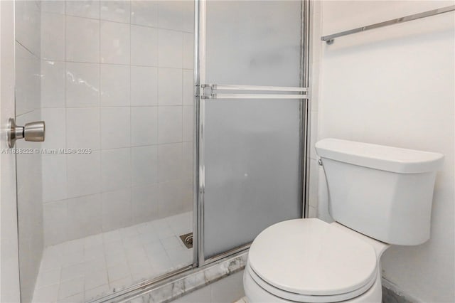 bathroom with toilet and a shower with shower door