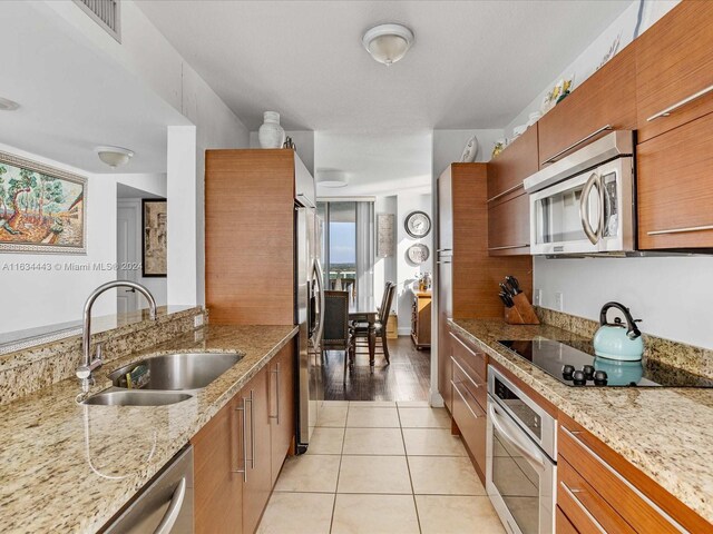 kitchen featuring light tile patterned floors, sink, a healthy amount of sunlight, and stainless steel appliances