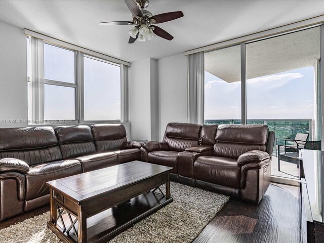 living room featuring ceiling fan, floor to ceiling windows, and wood-type flooring