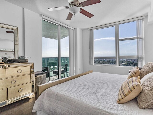 bedroom featuring access to outside, dark hardwood / wood-style flooring, ceiling fan, and multiple windows