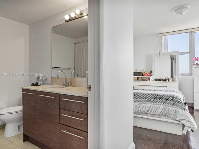 bathroom featuring toilet, vanity, and hardwood / wood-style flooring