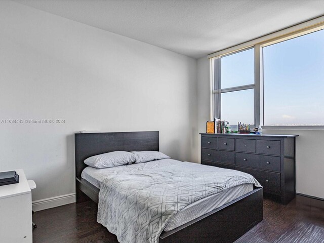 bedroom featuring dark hardwood / wood-style flooring and a textured ceiling