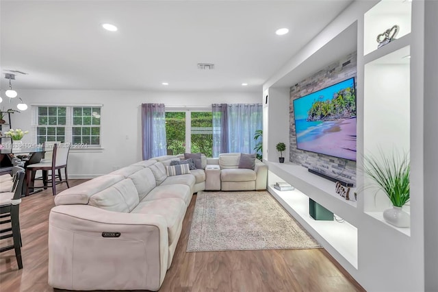 living room featuring a notable chandelier and light wood-type flooring