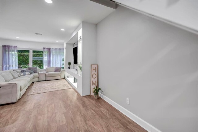 living room featuring vaulted ceiling and light hardwood / wood-style floors