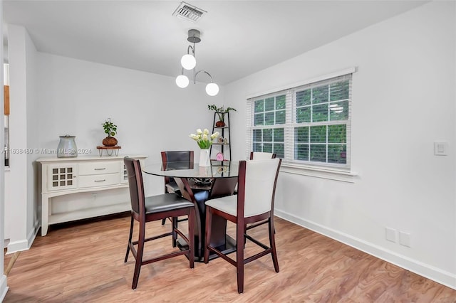 dining area featuring an inviting chandelier and light hardwood / wood-style floors