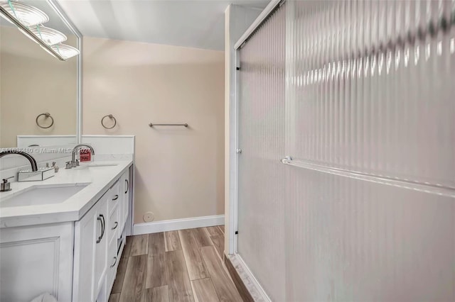 bathroom with double vanity, hardwood / wood-style floors, and lofted ceiling