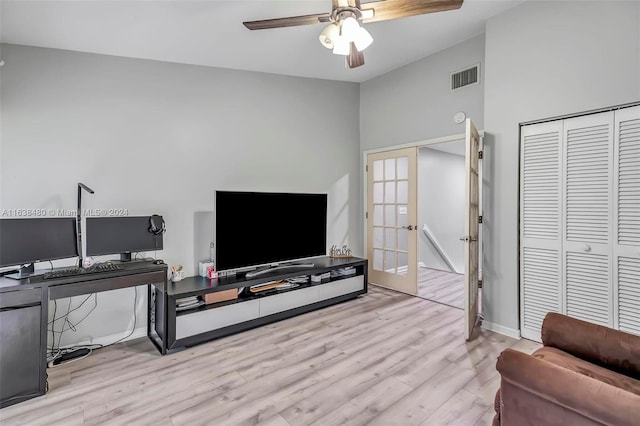 living room with ceiling fan, light wood-type flooring, french doors, and high vaulted ceiling