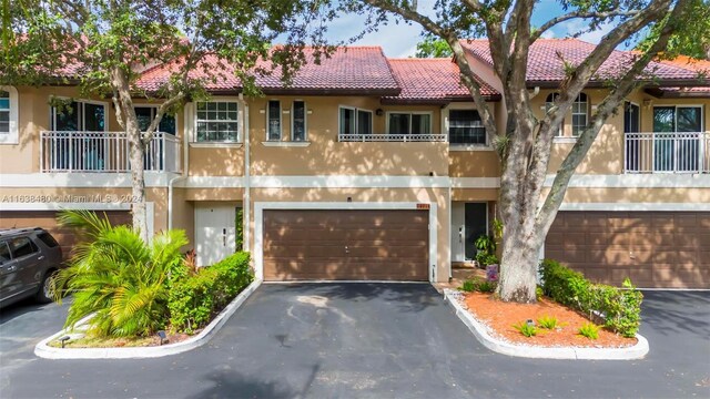 view of front of property featuring a garage and a balcony