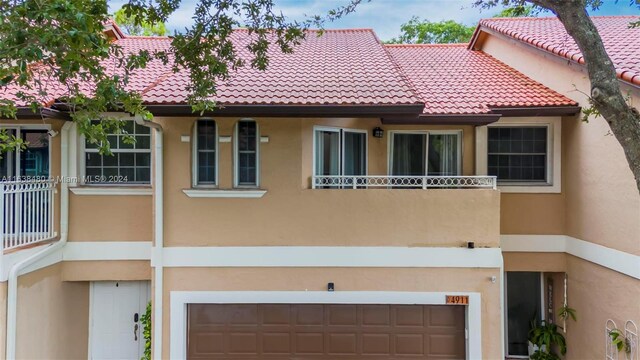 view of front of property featuring a balcony and a garage