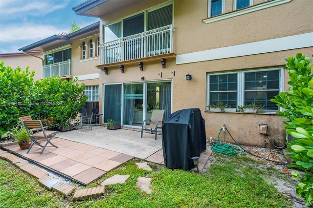 back of house with a balcony and a patio area