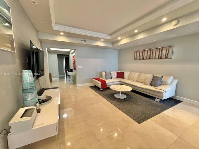 living room with a tray ceiling and ornamental molding